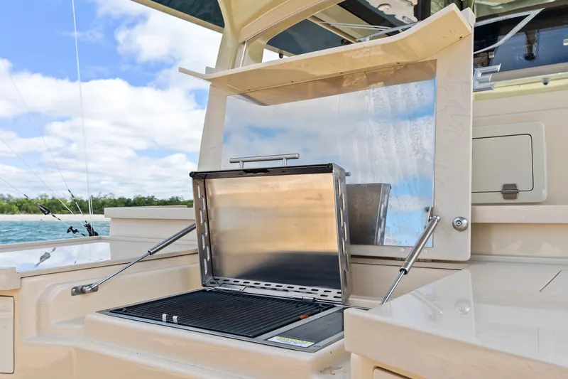 Slide: The Image of Outdoor grill on 2023 HCB 53 Suenos RXV boat, set against a scenic water backdrop. - 22