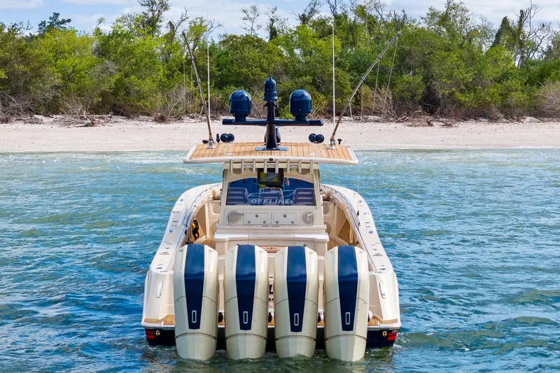 Slide: The Image of 2023 HCB 53 Suenos RXV boat with four engines near a sandy beach. - 3