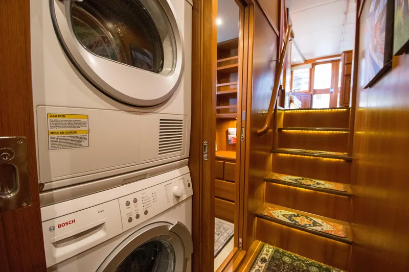 Slide: The Image of Laundry area and staircase inside a 2015 Fleming 55 yacht, featuring Bosch appliances. - 11