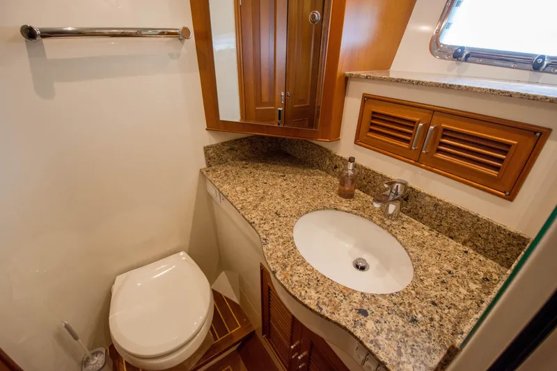 Slide: The Image of Luxurious bathroom in 2015 Fleming 55 yacht with granite countertop and wooden cabinetry. - 15
