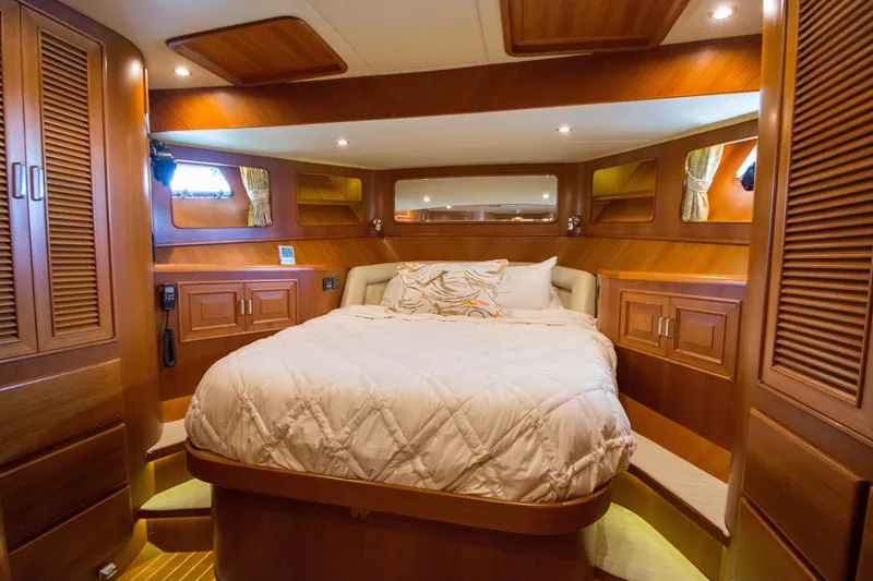 Slide: The Image of Luxurious cabin interior of a 2015 Fleming 55 yacht with wood paneling and cozy bedding. - 17