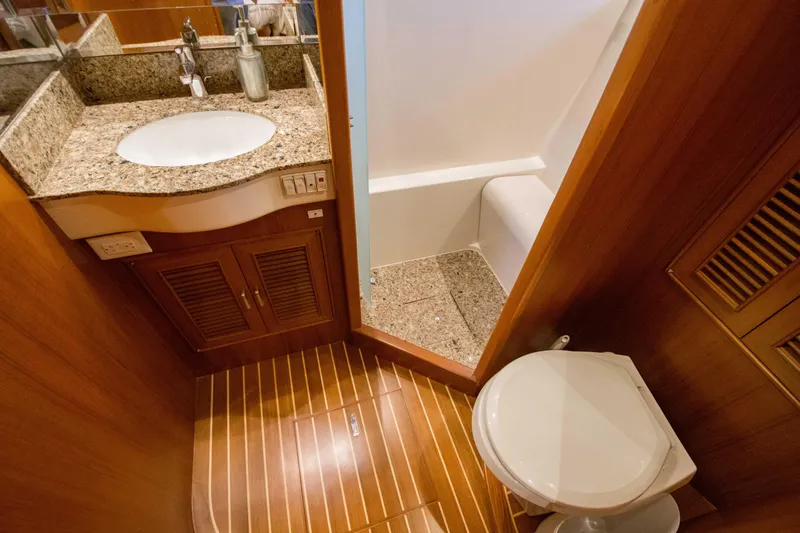 Slide: The Image of Luxurious bathroom in 2015 Fleming 55 yacht with granite countertop and wooden flooring. - 18
