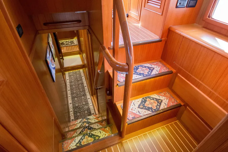 Slide: The Image of Staircase in 2015 Fleming 55 yacht with wooden finish and decorative rugs. - 20