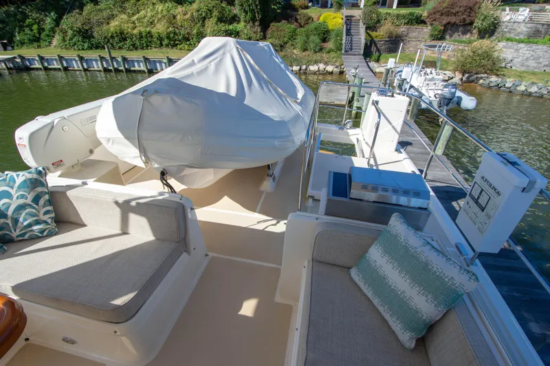 Slide: The Image of 2015 Fleming 55 yacht deck with seating, covered equipment, and scenic waterfront view. - 32