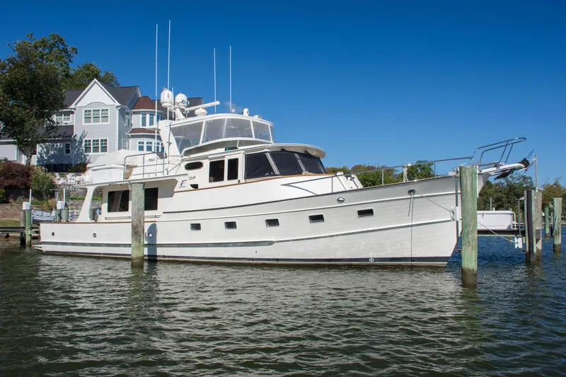 Slide: The Image of Luxurious 2015 Fleming 55 yacht docked near waterfront homes under clear blue sky. - 47