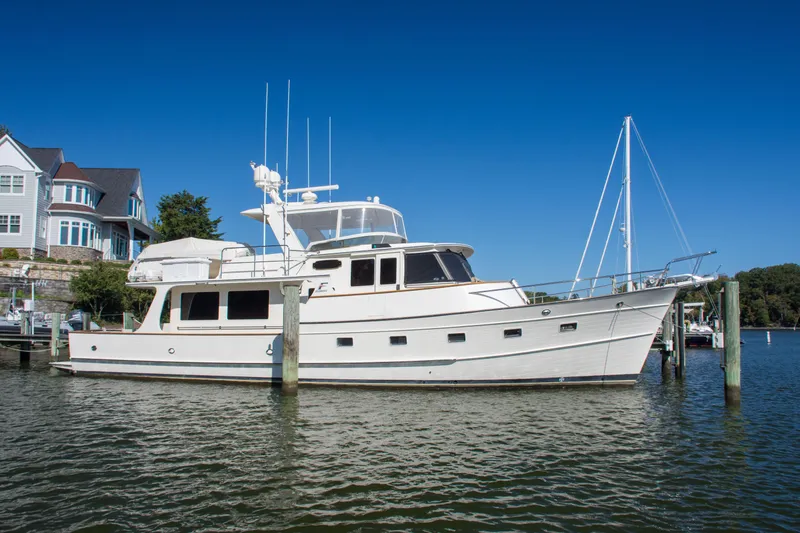 Slide: The Image of Luxury 2015 Fleming 55 yacht docked near waterfront homes. - 53