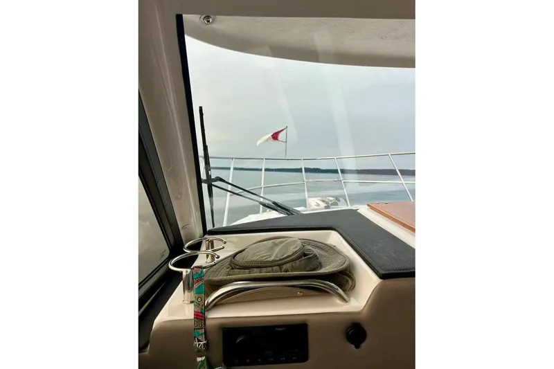 Slide: The Image of 2025 Cutwater C-248 Coupe on a serene lake with forested shoreline. - 13