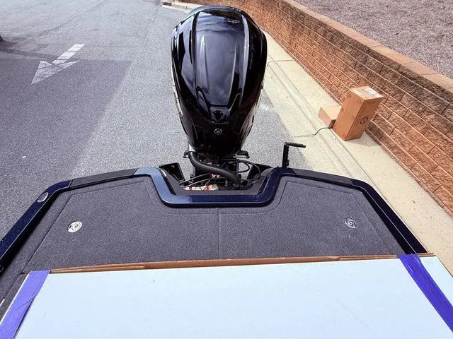 Slide: The Image of 2026 Ikon Boats LXE20 with outboard motor, viewed from above, parked on pavement. - 14