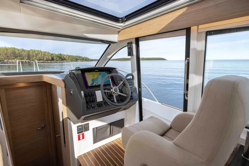 Slide: The Image of Interior of 2025 Nimbus 365 Coupe boat with modern helm and scenic view. - 14