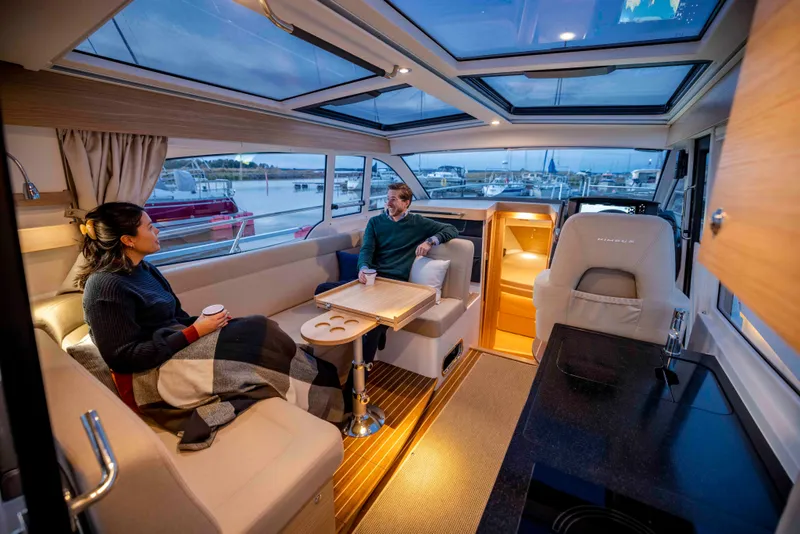 Slide: The Image of Interior of 2025 Nimbus 365 Coupe yacht with two people relaxing, modern design. - 19