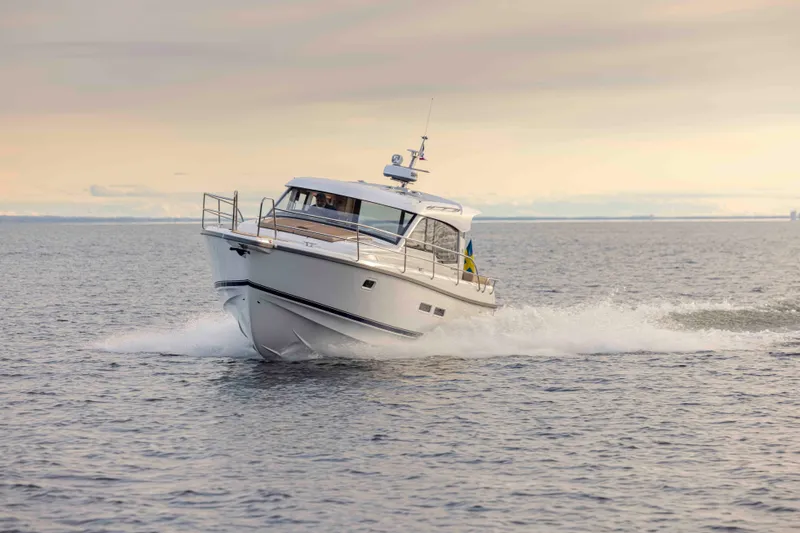 Slide: The Image of 2025 Nimbus 365 Coupe cruising on open water at sunset. - 2