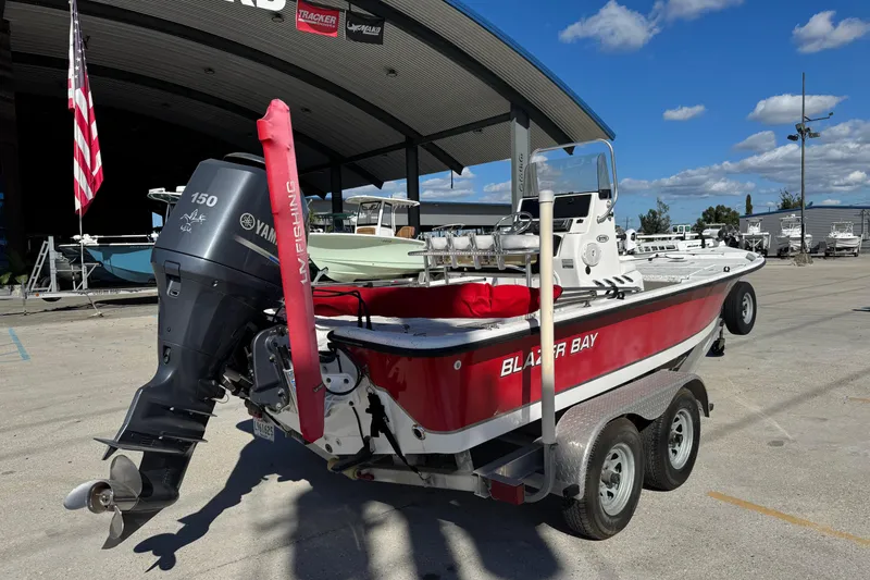 Slide: The Image of 2014 Blazer Bay 2170 boat with Yamaha motor on trailer, parked outdoors. - 2