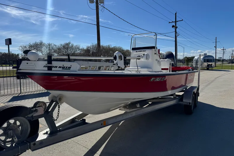 Slide: The Image of 2014 Blazer Bay 2170 boat on trailer, red and white, parked outdoors. - 6