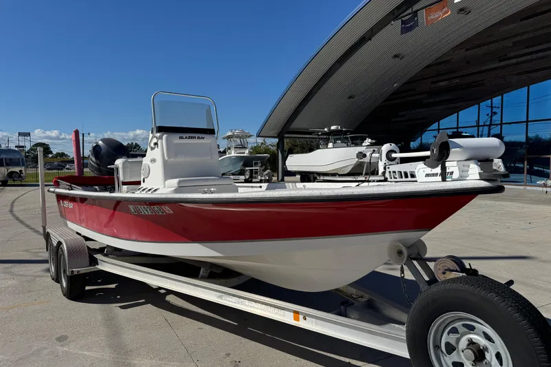 Slide: The Image of 2014 Blazer Bay 2170 boat on trailer, parked outdoors under clear blue sky. - 8