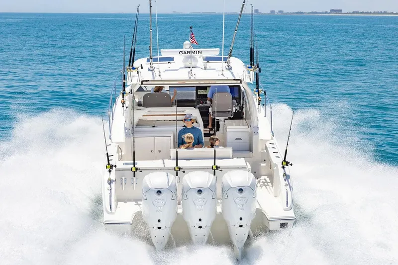 Slide: The Image of Manufacturer Provided Image: 2025 Pursuit OS 405 Offshore boat cruising on open water with triple engines. - 7