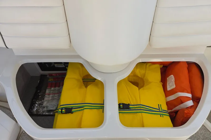 Slide: The Image of Storage compartment on a 2007 Sea Ray 290 Sundancer with life jackets and safety equipment. - 12