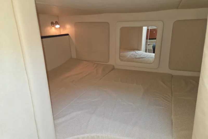 Slide: The Image of 2007 Sea Ray 290 Sundancer cabin interior with cozy bed and soft lighting. - 20