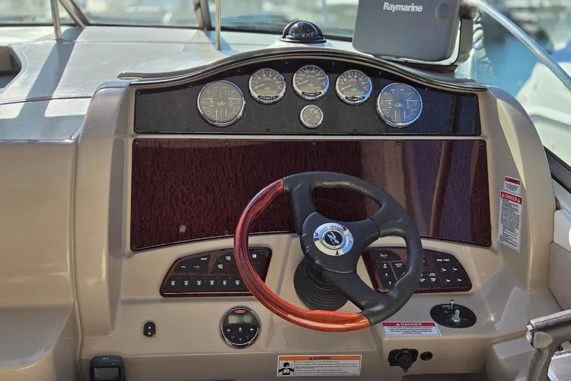 Slide: The Image of 2007 Sea Ray 290 Sundancer dashboard with steering wheel and navigation instruments. - 7