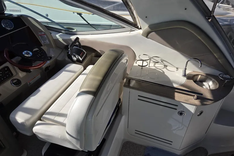 Slide: The Image of 2007 Sea Ray 290 Sundancer helm with steering wheel, seating, and compact sink area. - 8