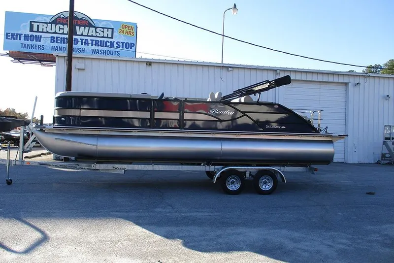The Image of 2026 Bentley Pontoons Legacy 243 Swingback on trailer, parked near a truck wash facility. - 1