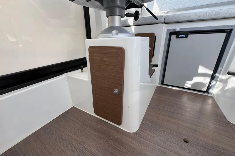 Slide: The Image of Interior of 2026 Jeanneau NC Sport 795 Series 2 boat, featuring wood accents and storage. - 18