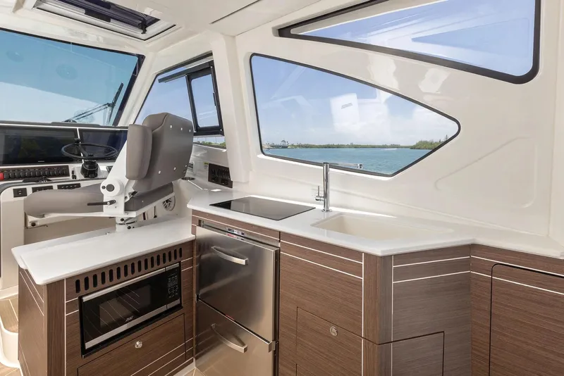 Slide: The Image of Manufacturer Provided Image: 2025 Pursuit OS 445 Offshore interior with modern kitchen and ocean view. - 12
