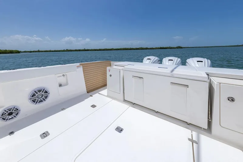 Slide: The Image of Manufacturer Provided Image: 2025 Pursuit OS 445 Offshore boat deck with ocean view and triple engines. - 15