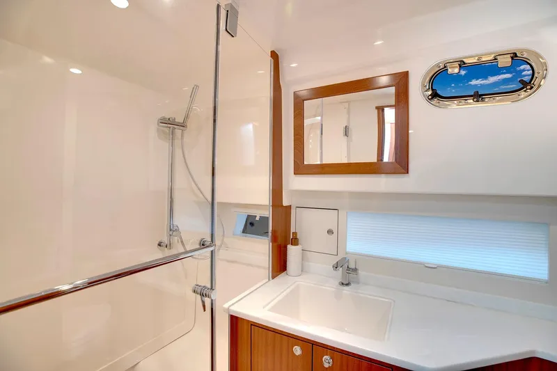 Slide: The Image of Manufacturer Provided Image: Luxurious bathroom in 2025 Pursuit OS 445 Offshore yacht with modern fixtures and porthole window. - 22