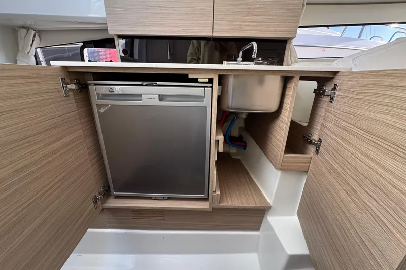 Slide: The Image of 2026 Jeanneau Leader 9.0 WA Series 2 boat interior kitchen with sink and fridge. - 14