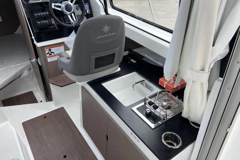 Slide: The Image of Interior of 2026 Jeanneau NC 795 Series 2 boat with helm, sink, and stove. - 19