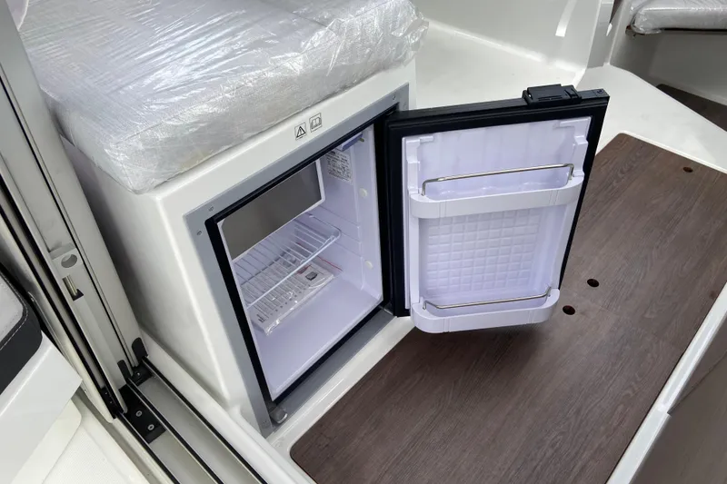 Slide: The Image of 2026 Jeanneau NC 795 Series 2 boat interior with open mini fridge. - 20