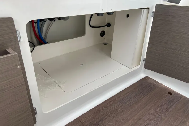 Slide: The Image of Interior storage compartment of 2026 Jeanneau NC 795 Series 2 boat, featuring wood accents. - 22