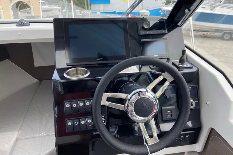 Slide: The Image of Steering console of 2026 Jeanneau NC 795 Series 2 boat with modern navigation displays. - 23