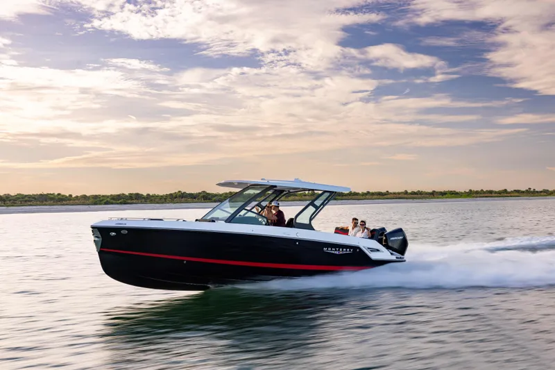 Slide: The Image of 2026 Monterey Elite 30 OB cruising on water under a vibrant sky. - 14