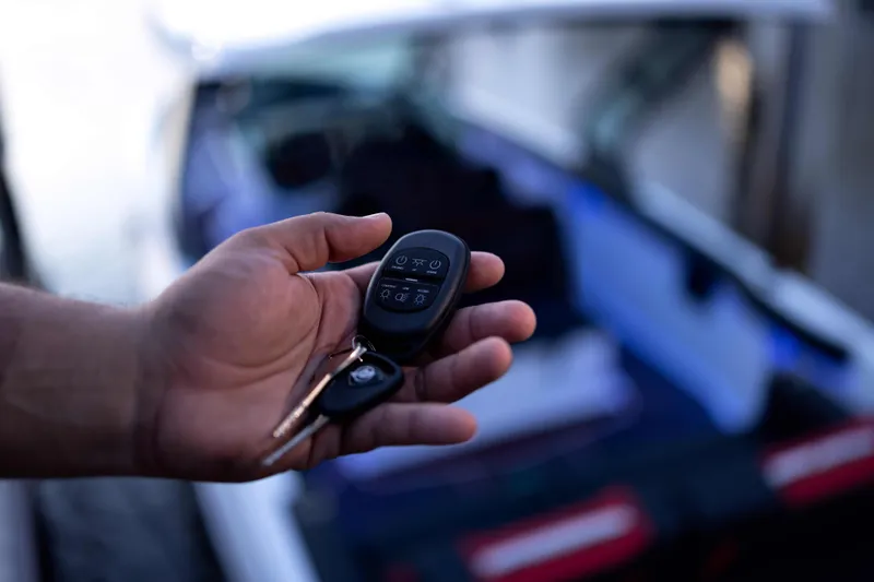 Slide: The Image of Hand holding keys for 2026 Monterey Elite 30 OB boat, blurred background. - 21