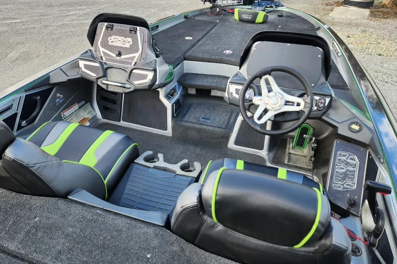 Slide: The Image of 2019 Skeeter FX21 boat interior with black and green seats, steering wheel, and control panel. - 19
