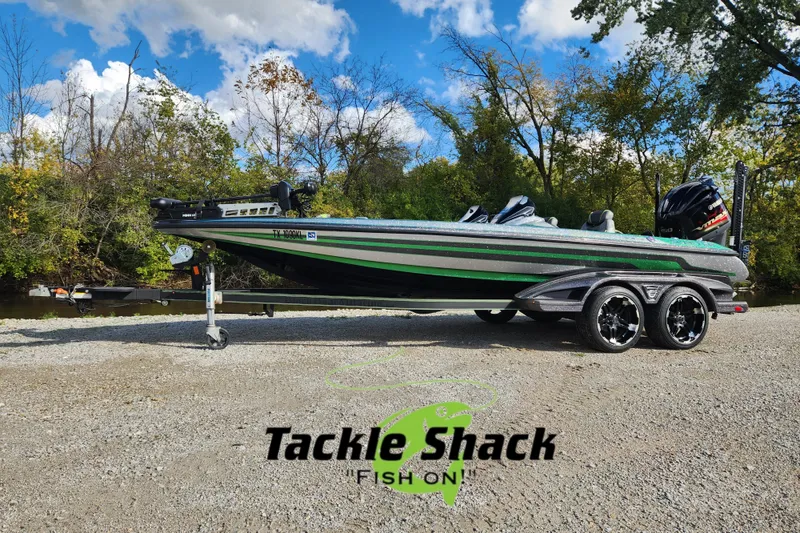 Slide: The Image of 2019 Skeeter FX21 fishing boat on trailer, parked outdoors near trees and water. - 3