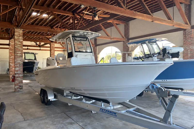 The Image of 2026 Sportsman Masters 267 Bay Boat on trailer in a wooden boathouse. - 0