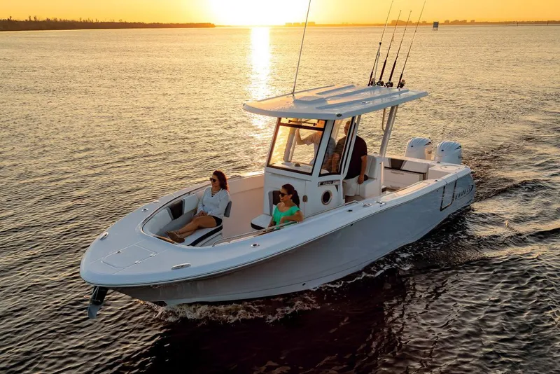 Slide: The Image of Manufacturer Provided Image: 2025 Robalo R270 Center Console boat cruising at sunset on calm waters. - 2