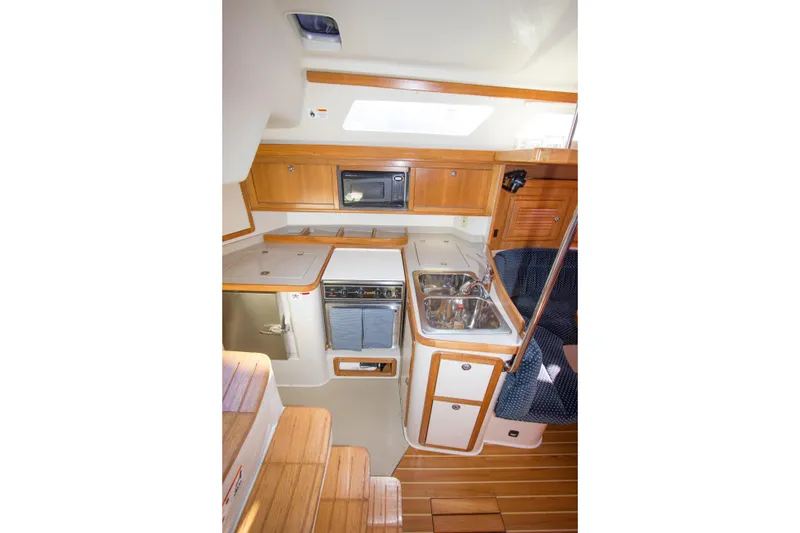 Slide: The Image of 2008 Catalina 42 MkII yacht interior kitchen with wood cabinetry and modern appliances. - 16