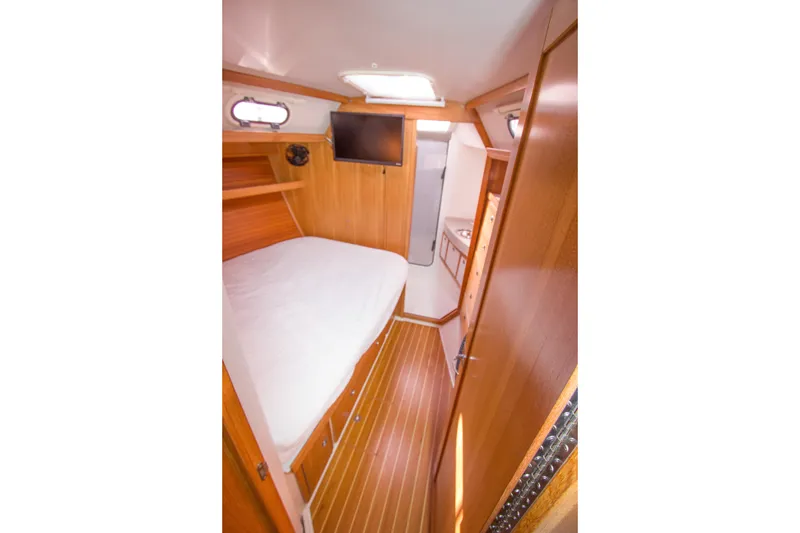 Slide: The Image of Cozy cabin interior of 2008 Catalina 42 MkII sailboat with wood finish and bed. - 19
