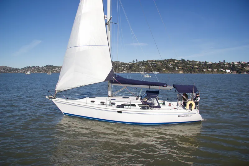 Slide: The Image of 2008 Catalina 42 MkII sailboat cruising on a sunny day with scenic shoreline. - 2