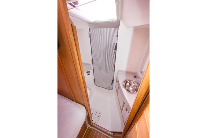 Slide: The Image of 2008 Catalina 42 MkII yacht bathroom with shower, sink, and wooden accents. - 22