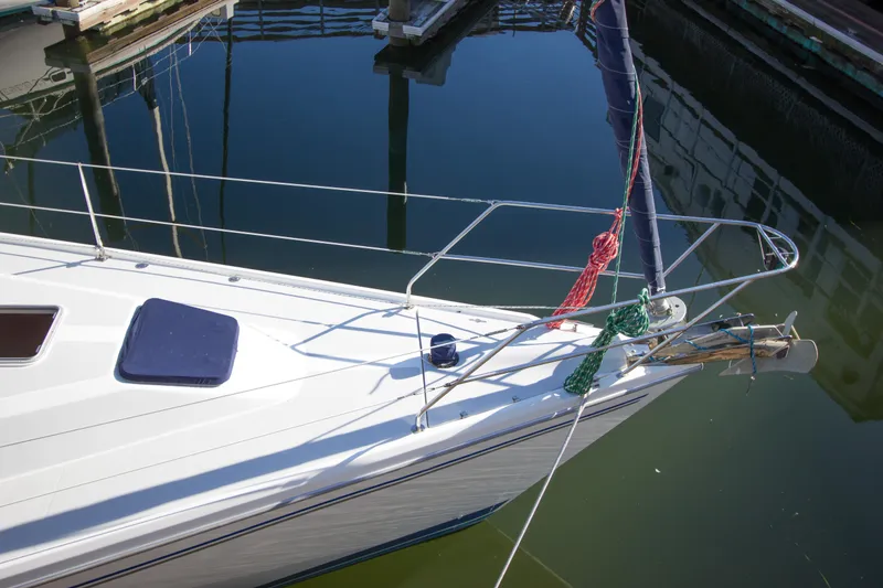 Slide: The Image of 2008 Catalina 42 MkII sailboat bow at marina, reflecting in calm water. - 35