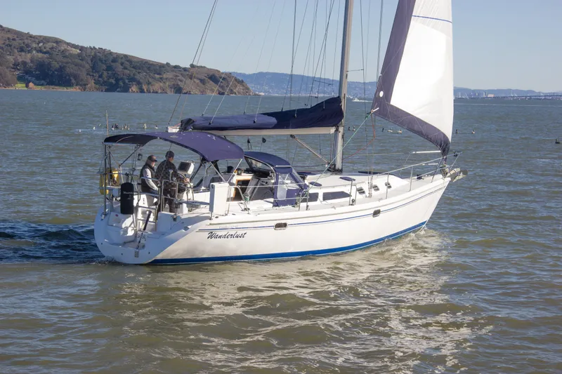 Slide: The Image of 2008 Catalina 42 MkII sailboat cruising on a sunny day with scenic coastline backdrop. - 4