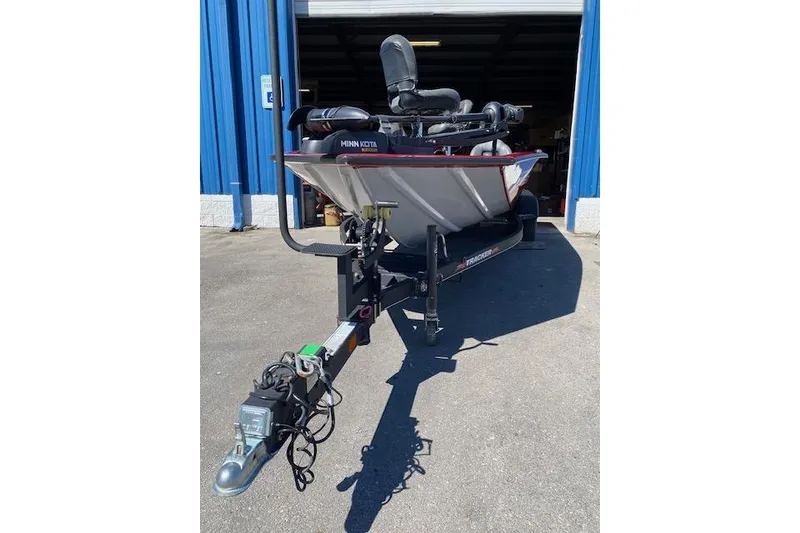 Slide: The Image of 2021 Bass Tracker Pro Team 195 TXW Team Edition boat on trailer outside blue building. - 4