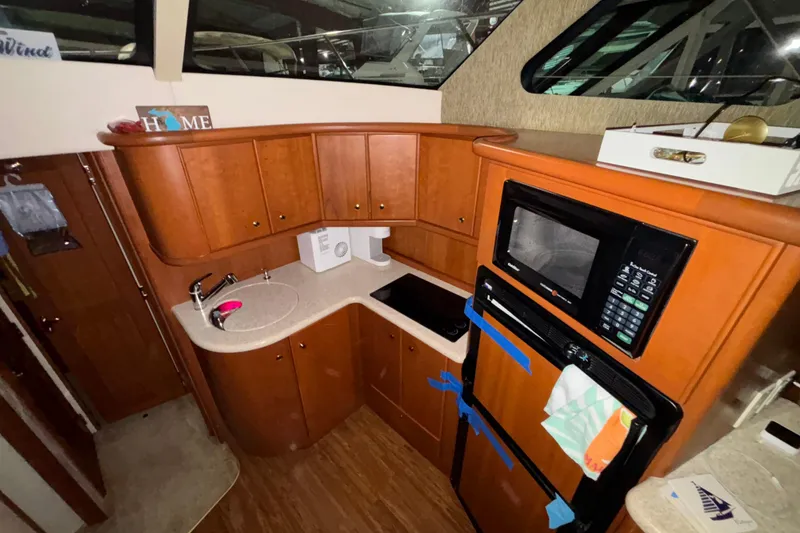 Slide: The Image of 2005 Silverton 34 Convertible cabin with cozy bed and wooden storage drawers. - 26