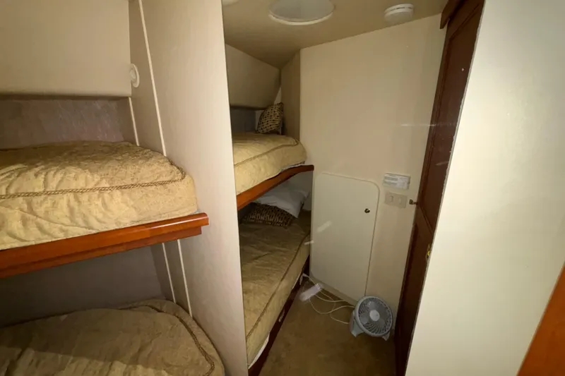 Slide: The Image of 2005 Silverton 34 Convertible yacht kitchen with sink, stovetop, and wooden cabinetry. - 28