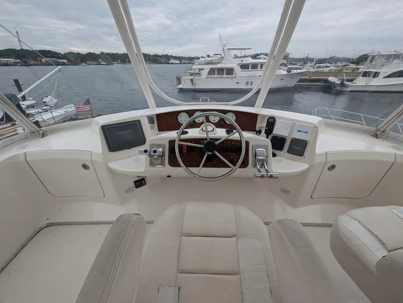Slide: The Image of 2005 Silverton 34 Convertible boat interior with white seating and helm. - 6