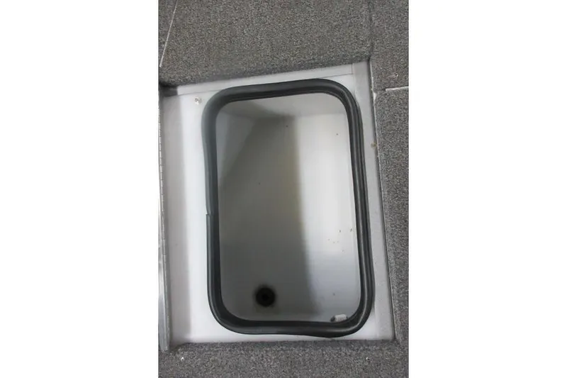 Slide: The Image of 2013 Alumacraft Competitor 175 SC boat storage compartment with gray carpeted edges. - 13